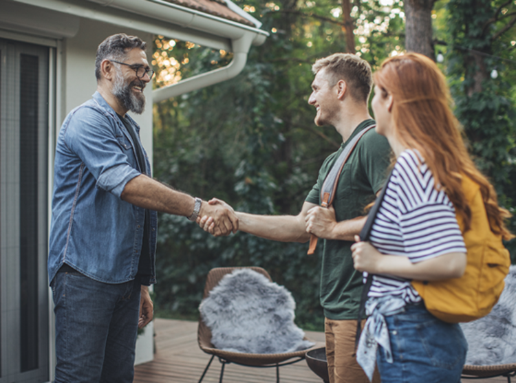 A couple shaking a man's hand